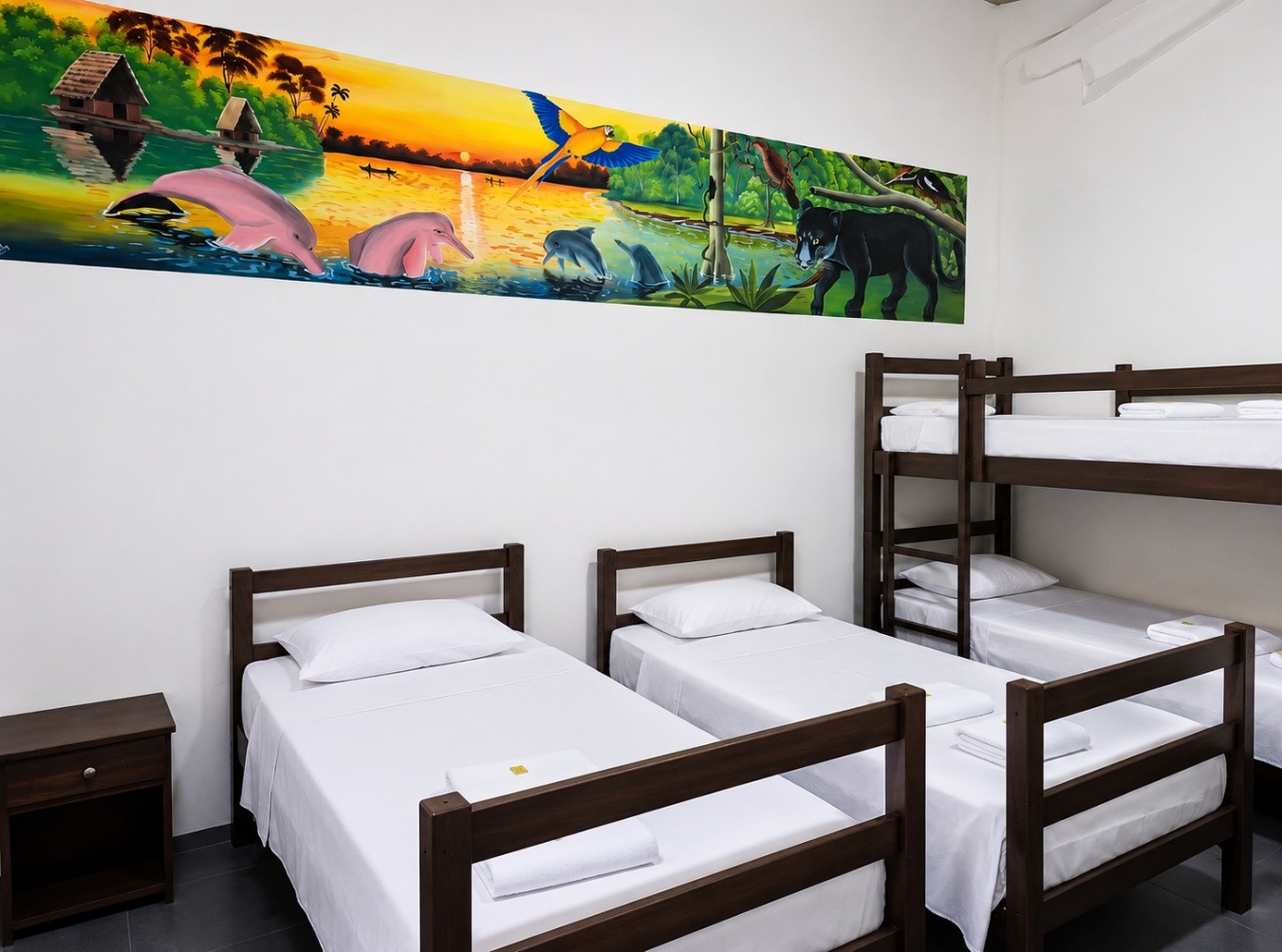 Suite Amazonía Familiar en El Jaguar Casa Hotel con camas y mural de delfines rosados y jaguar
