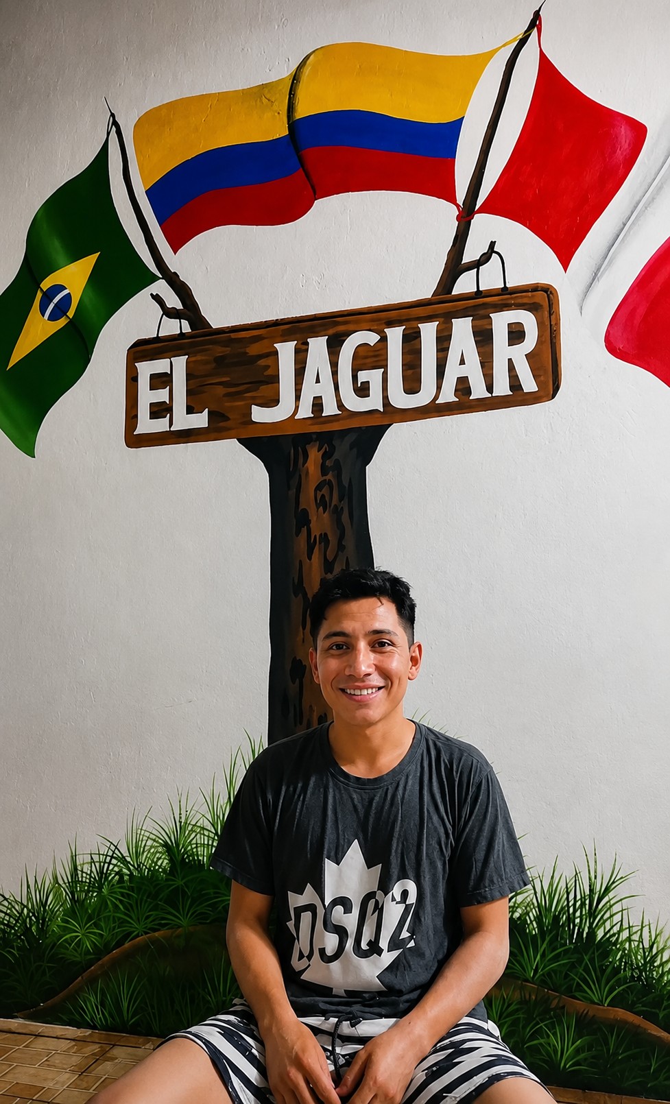 Huésped bajo el letrero de El Jaguar con las banderas de Colombia, Brasil y Perú, símbolo de la triple frontera