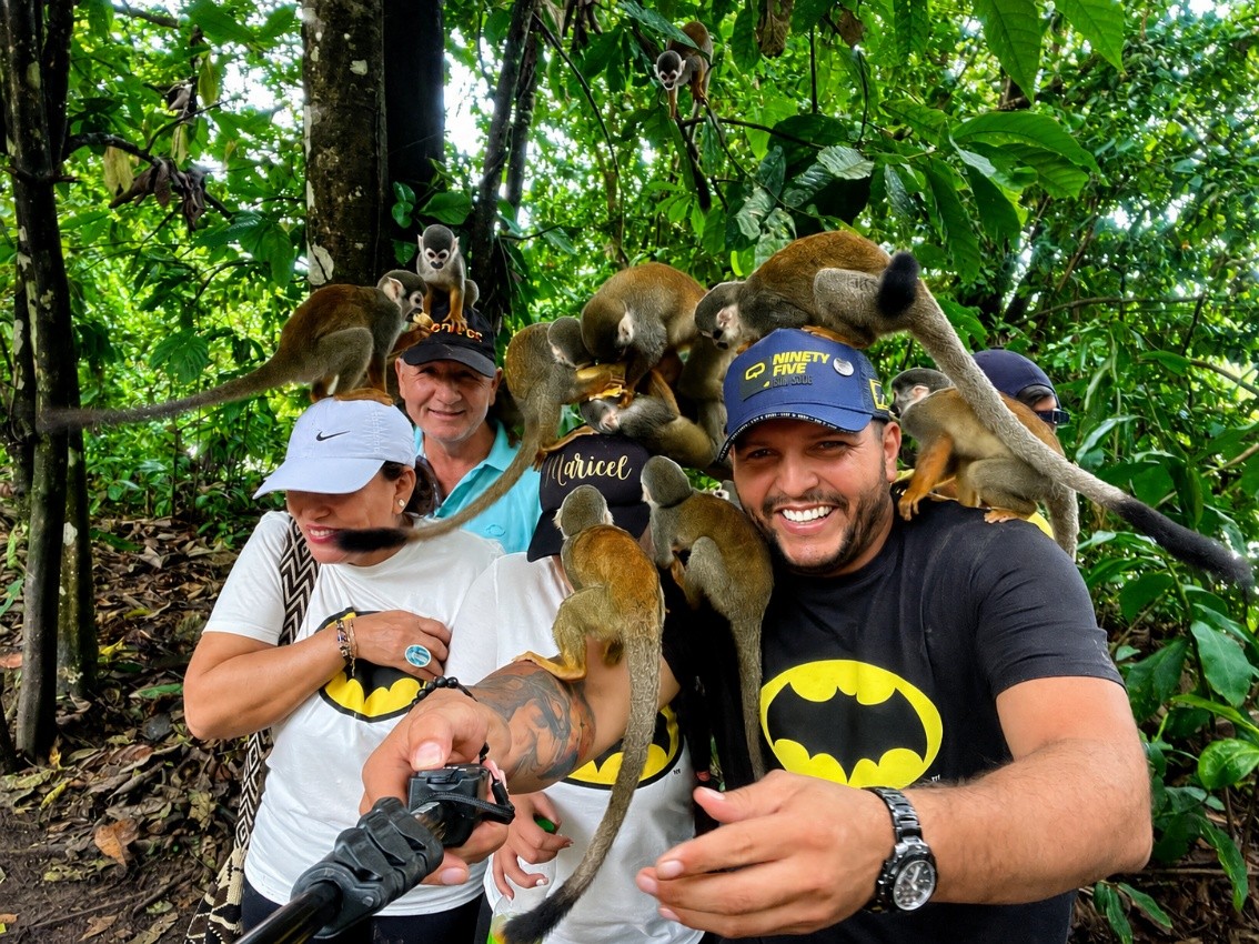 Turistas tomándose una selfie en la selva rodeados de monos ardilla